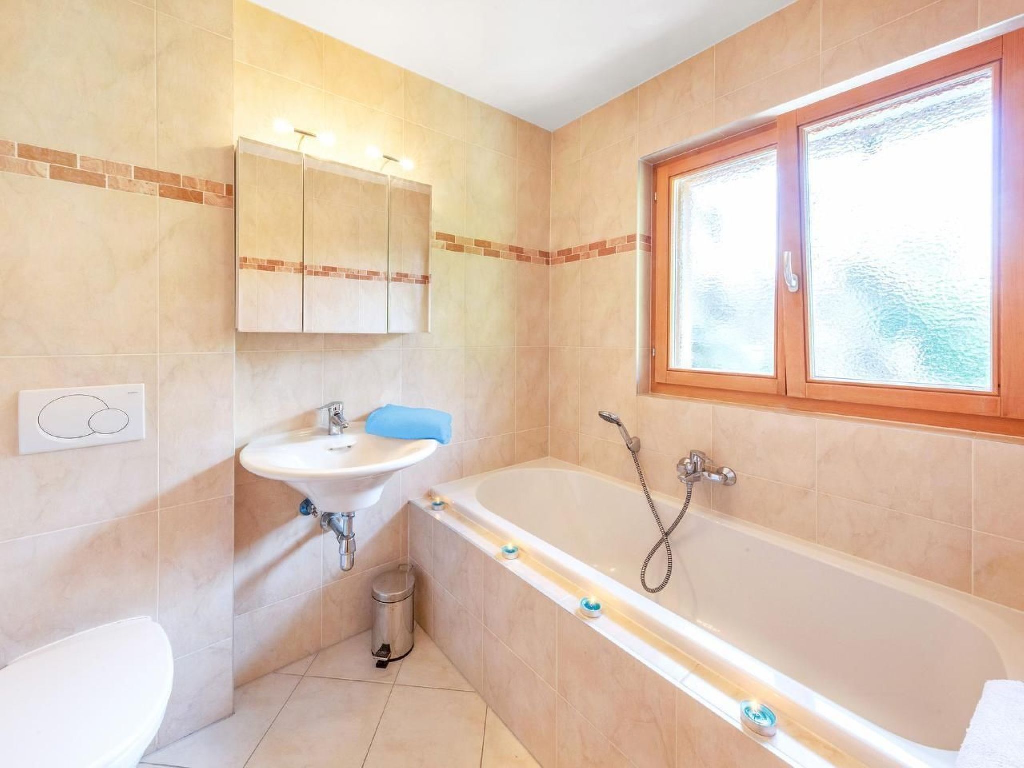 Ein Badezimmer mit Waschbecken, Spiegel, Schminktisch, Badewanne und Fenster.