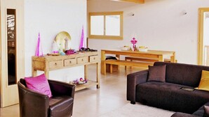 A spacious living area with a high ceiling, wooden beams, a dining table, and a sofa. - Chalet Chaud by Interhome (La Tzoumaz)