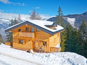 A wooden chalet with a balcony, set against a snowy mountain backdrop. - Chalet Chaud by Interhome (La Tzoumaz)