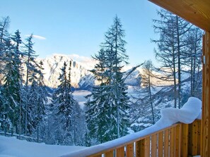 A wooden balcony with a view of snow-covered trees and mountains. - Chalet Chaud by Interhome (La Tzoumaz)