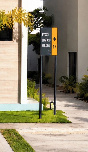 A sign indicating the direction to the Edificio Building, number 17, with a clear path leading to the entrance. - Your  Peaceful tropical  Punta Cana Getaway 2BR Condo with all amenities & more (Punta Cana)