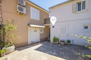 A building with a white door, air conditioning units, and potted plants. - Summer Breeze Dominique 2BR Island Retreat, Veli Iž, Croatia (Veli Iž)
