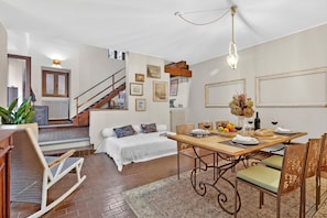 A spacious living area with a dining table set for two, a sofa, a staircase, and a view of the outdoors. - The Place to Be, Outdoor dining, Laveno Mombello, Italy (Laveno Mombello)