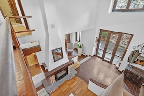 A multi-level interior with a fireplace, wooden flooring, and a view through glass doors. - The Place to Be, Outdoor dining, Laveno Mombello, Italy (Laveno Mombello)