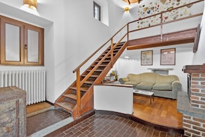 A staircase with wooden railings, a radiator, a sofa, and a fireplace. - The Place to Be, Outdoor dining, Laveno Mombello, Italy (Laveno Mombello)
