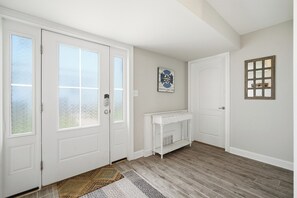 Ein Zimmer mit weißer Tür, Kamin, Teppich und einer Wandtafel.