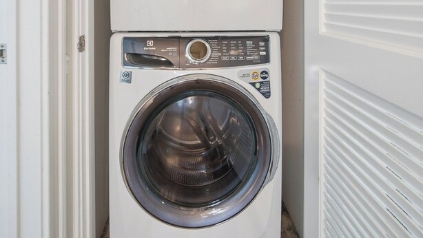 A stacked washer and dryer unit in a narrow hallway. - Luxury 6BR 3 BA Beach Home Sleeps 14 Huge Front Porch Walk To Beach and Downtown (Ocean City)