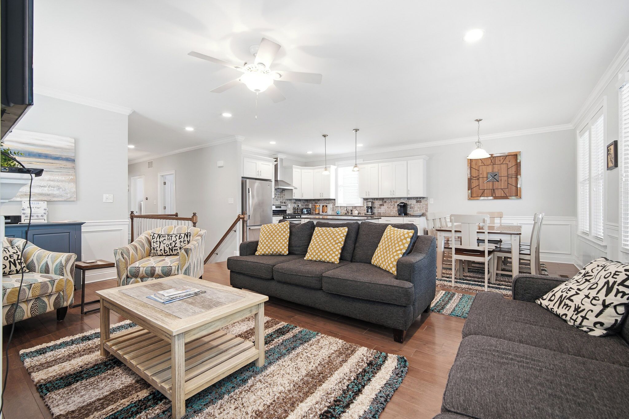 A modern living room with a sofa, coffee table, and patterned rugs.