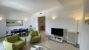 Ein modernes Wohnzimmer mit Essbereich, einem Flachbildfernseher und einer Heizung.