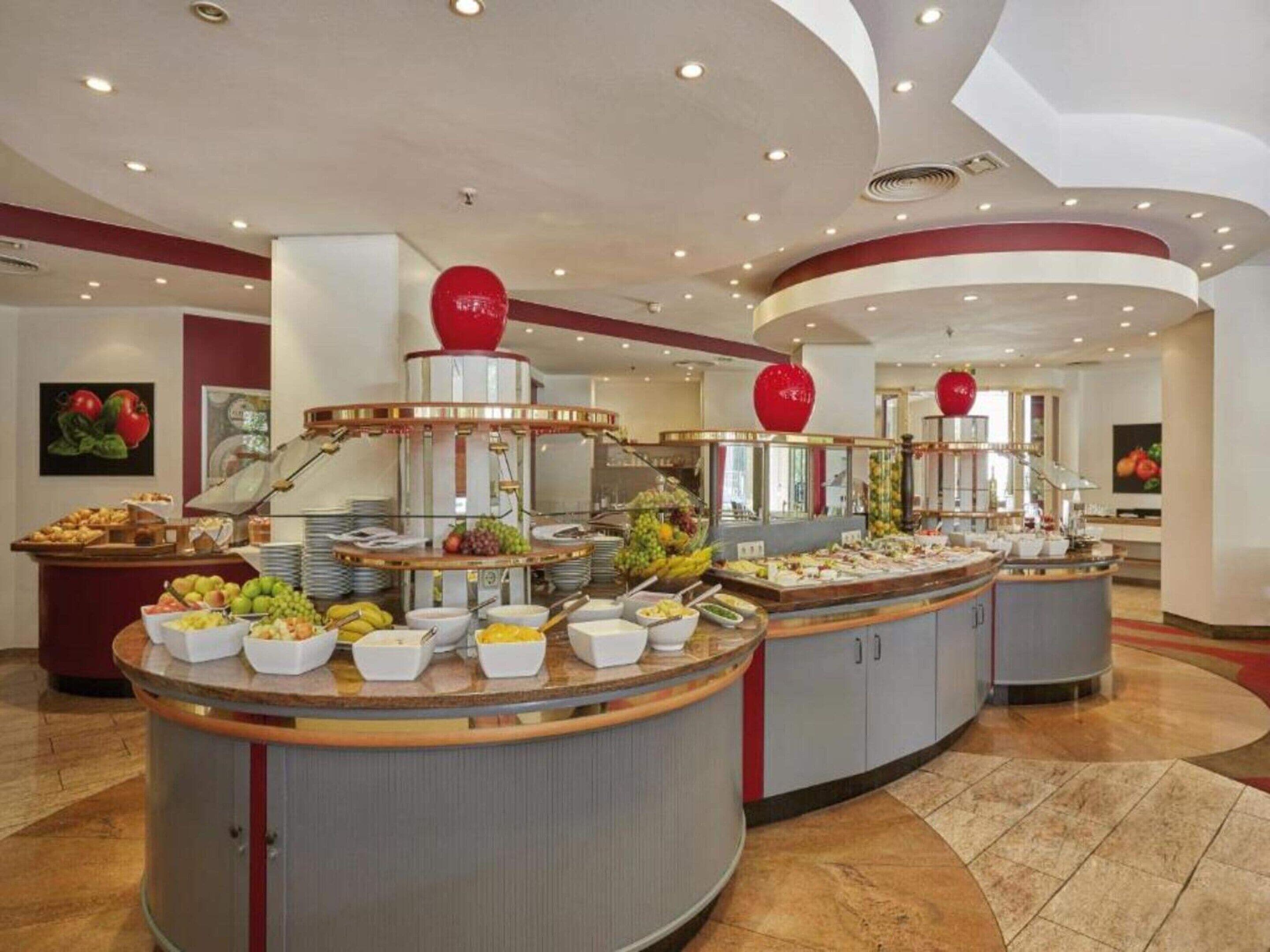 Een buffetopstelling met meerdere aanzitpunten, elk met diverse gerechten en een centraal decoratief element.