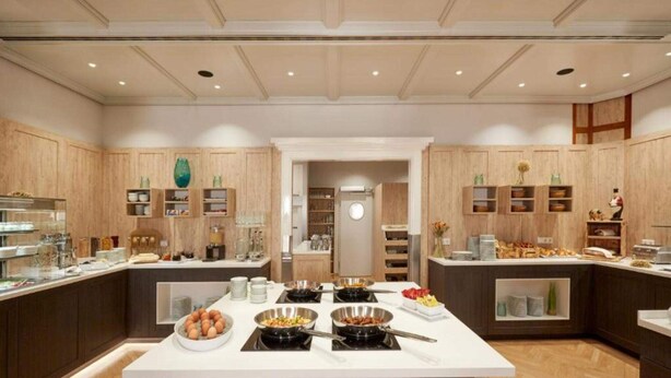 A modern kitchen with wooden cabinets, a central island with breakfast items, and built-in appliances. - 2 Person Holiday Park Home in Herrenberg (Herrenberg)
