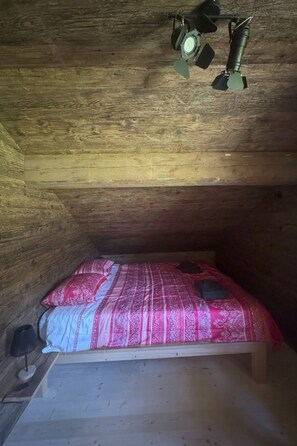 A small, single-bed room with a sloped ceiling and wooden walls. - La Chotte du Musher, (Champery), by Interhome (Champery)