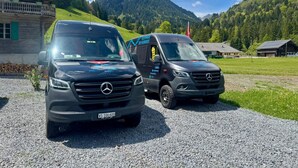 Two Mercedes vans parked on a gravel surface with a mountainous backdrop. - La Chotte du Musher, (Champery), by Interhome (Champery)