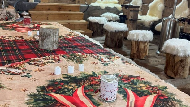 A cozy room with a wooden interior, a Christmas-themed tablecloth, and a decorative wreath on the wall. - La Chotte du Musher, (Champery), by Interhome (Champery)