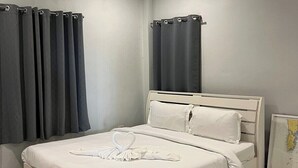 A modern hotel room with a bed, curtains, a framed map, and an air conditioning unit.