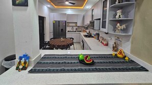 Una cucina moderna con zona pranzo, frigorifero, forno a microonde e ventilatore a soffitto.
