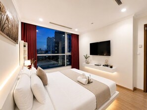 Ein modernes Hotelzimmer mit einem großen Bett, einem an der Wand montierten Fernseher und Blick auf die Stadt durch das Fenster.