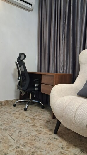 Une pièce comprenant un bureau, une chaise et un canapé.