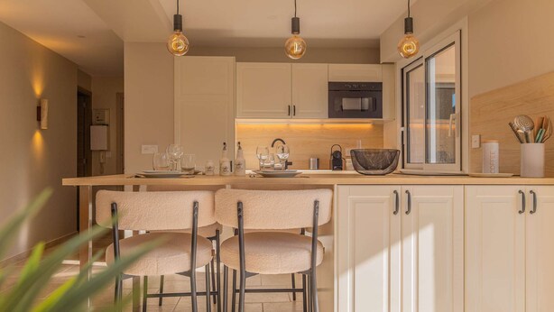 A modern kitchen with a central island, bar stools, pendant lighting, and a view of the outdoors. - BRAND-NEW APARTMENT - SWIMMING POOL - PRIVATE PARKING - WALKING DISTANCE TO THE TOWN CENTRE AND... (STE MAXIME)