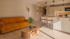 A modern living room with a sofa, a coffee table, and a plant. - BRAND-NEW APARTMENT - SWIMMING POOL - PRIVATE PARKING - WALKING DISTANCE TO THE TOWN CENTRE AND... (STE MAXIME)