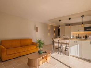 Ein modernes Wohnzimmer mit einer Couch, einem Couchtisch und einer Pflanze.