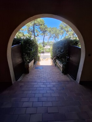 A paved pathway leading to a gated entrance with a view of trees and a clear sky. - Arcachon 4BR near Dune du Pilat, walking distance to the beach (La Teste-de-Buch)