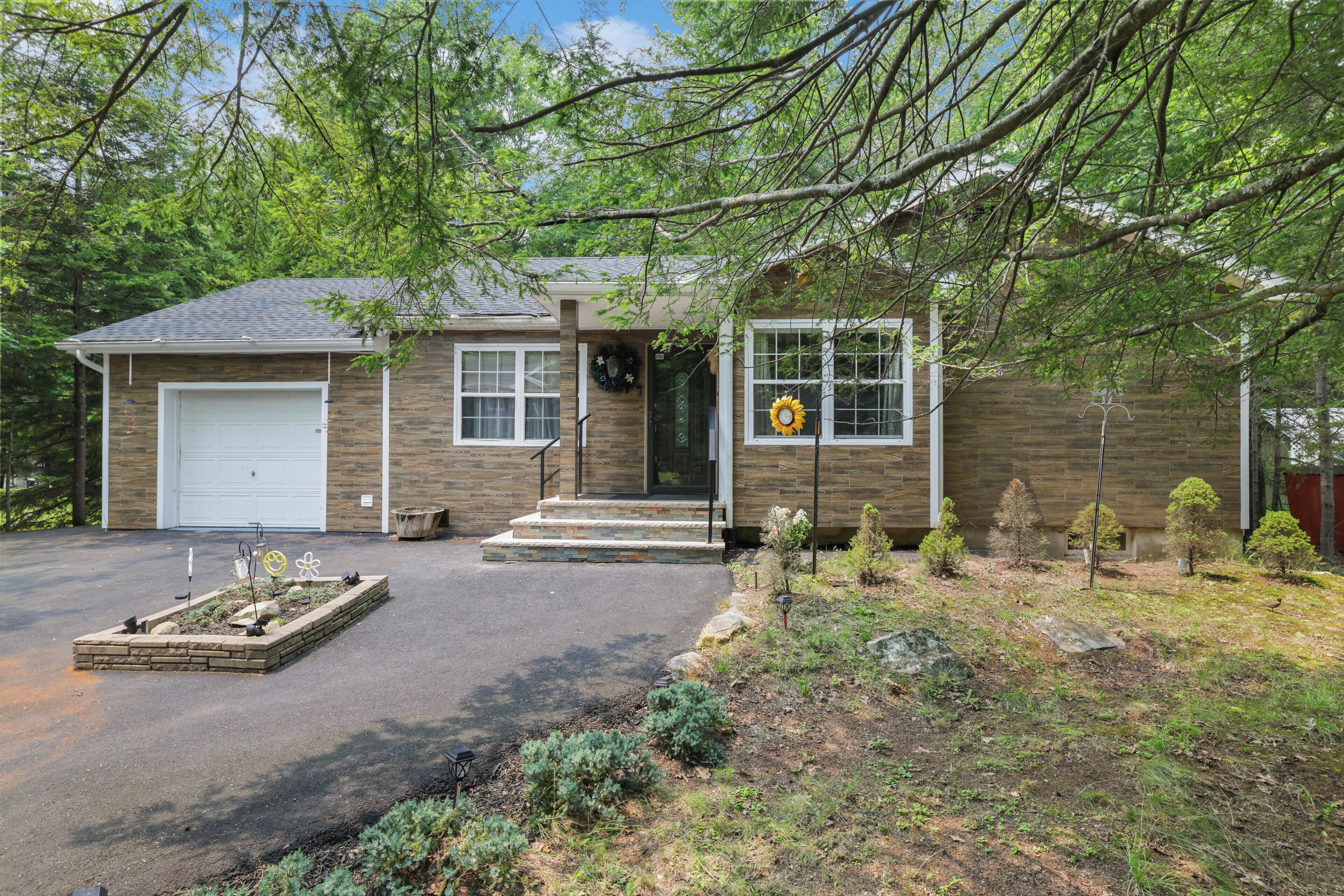 A two-story house with a garage, a front porch, and a landscaped yard.