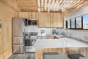 Eine moderne Küche mit Holzwänden, Edelstahlgeräten und einer großen Kochinsel.