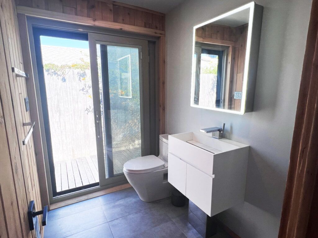 Une salle de bain moderne avec des toilettes, un lavabo et un grand miroir.