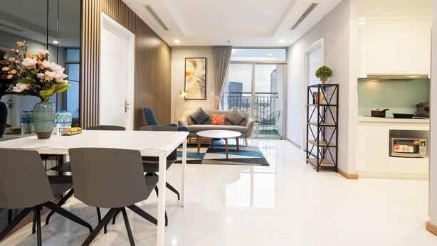Una sala de estar moderna con una mesa de comedor, sillas, un sofá y una zona de cocina con microondas.