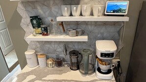 A kitchen with a coffee bar, including a coffee maker, mugs, and coffee beans. -  Modern 2BR • 10 Min to Sky Harbor & Downtown (Phoenix)