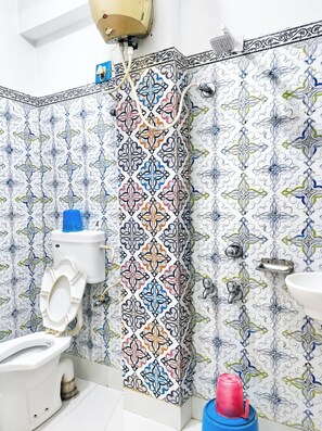 Douche, douche à « effet pluie », chaussons, serviettes fournies