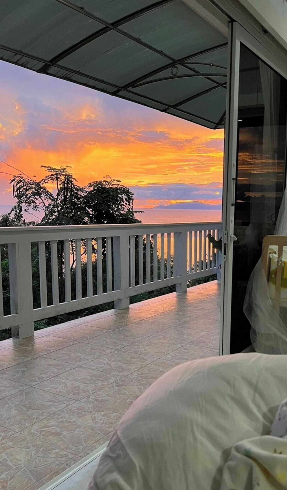 A balcony with a view of a sunset.