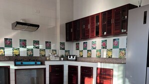 A modern kitchen with a central island, built-in cabinets, and a stainless steel refrigerator.