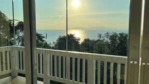 A balcony with a view of the sea and a clear sky.