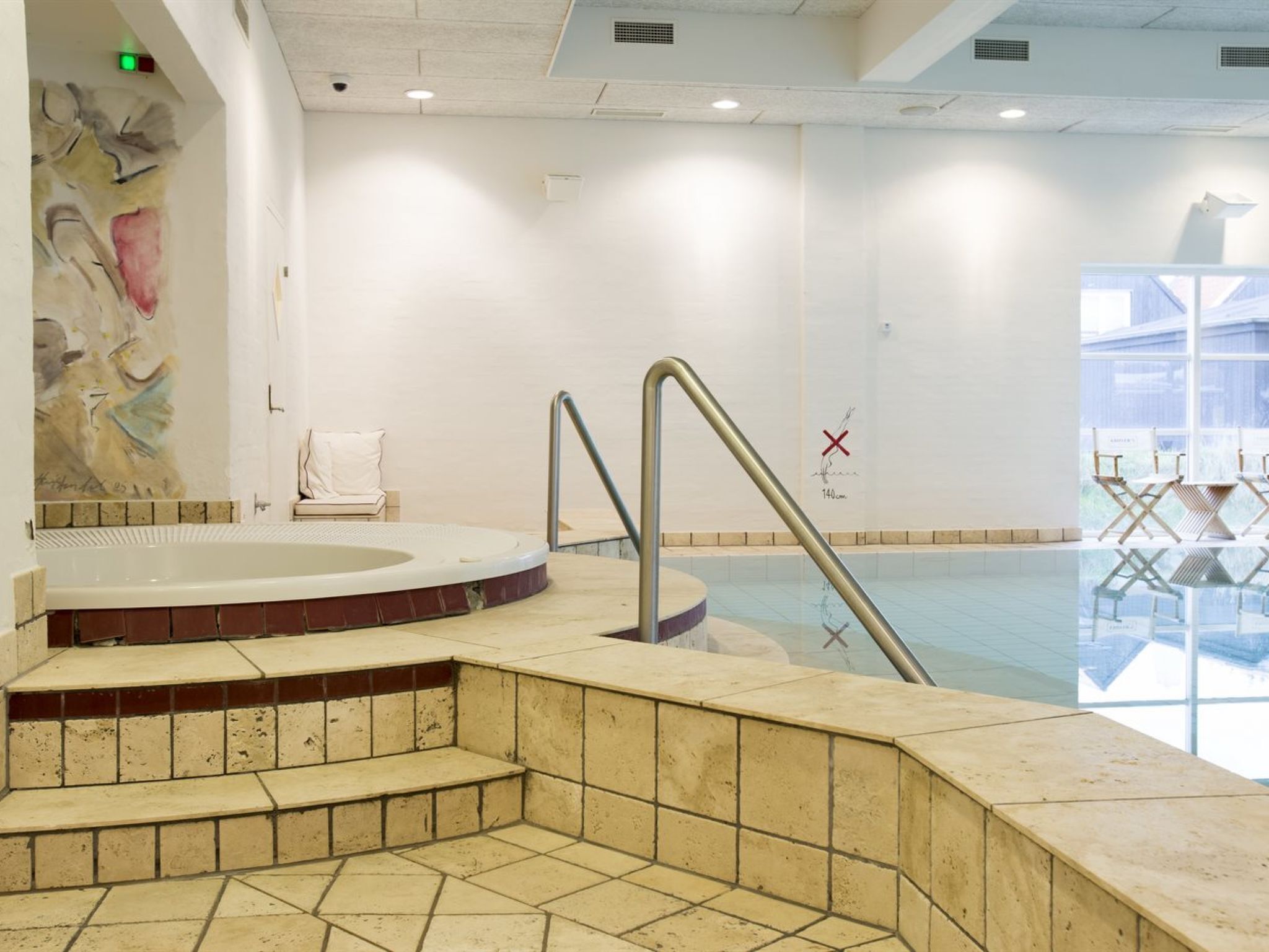 Uma piscina com degraus de acesso, um porta-toalhas e vista para o exterior.