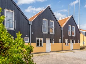 A row of modern, dark-colored houses with orange roofs, white windows, and balconies. - "Ehlin" - 900m from the sea by Interhome (Skagen)