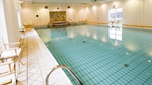 A swimming pool with tiled flooring, a bench, and a chair near the poolside. - "Ehlin" - 900m from the sea by Interhome (Skagen)