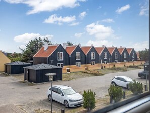 A row of dark-colored houses with red-tiled roofs and a white car parked in the foreground. - "Ehlin" - 900m from the sea by Interhome (Skagen)