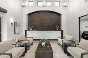 A reception area with a dark wooden backdrop, a glass partition, and seating with plants. - Lux resort Apartment St Augustine Baptist Wolfson UF Hospital Pool Gym (St. Augustine)