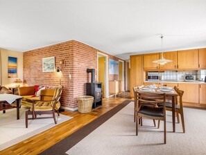 Eine moderne Küche mit Holzschränken, einem eingebauten Backofen und einer Mikrowelle.