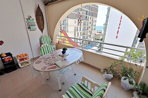 A balcony with a table, chairs, a flag, and potted plants. - Sabine - apartment located in the heart of Calpe (Calpe)
