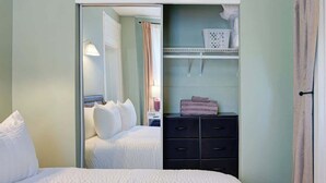 Un dormitorio con cama, armario y espejo.