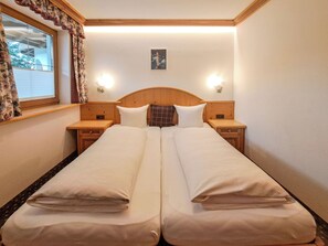 Ein Doppelbett mit zwei Nachttischen, einem Kopfteil und einer Wandleuchte.
