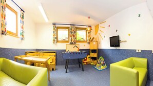 A children's playroom with a foosball table, play area, and seating. - Schatzberg by Interhome (Auffach)