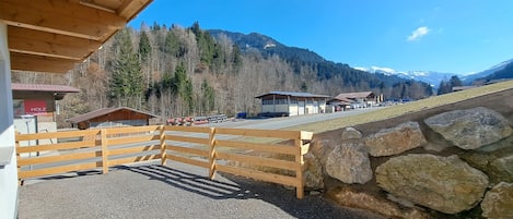 Un bâtiment en bois avec une allée en gravier et un mur en pierre.