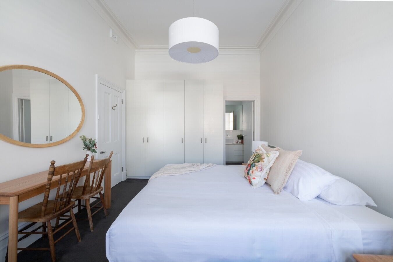 Ein Schlafzimmer mit einem Bett, einem Holzbett, einem Schreibtisch und einem Kleiderschrank.