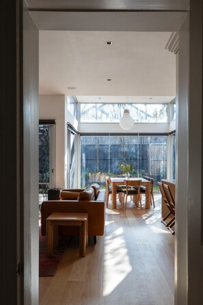 Een modern interieur met een eetgedeelte, zitplaatsen en een uitzicht door grote ramen.