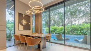 Un comedor moderno con una pared de vidrio, una mesa redonda y sillas.