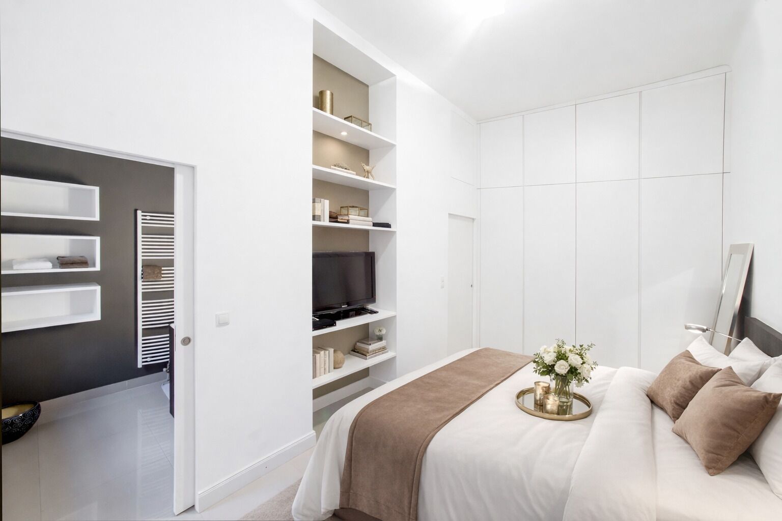 A bedroom with a bed, bedside table, and a built-in wardrobe.